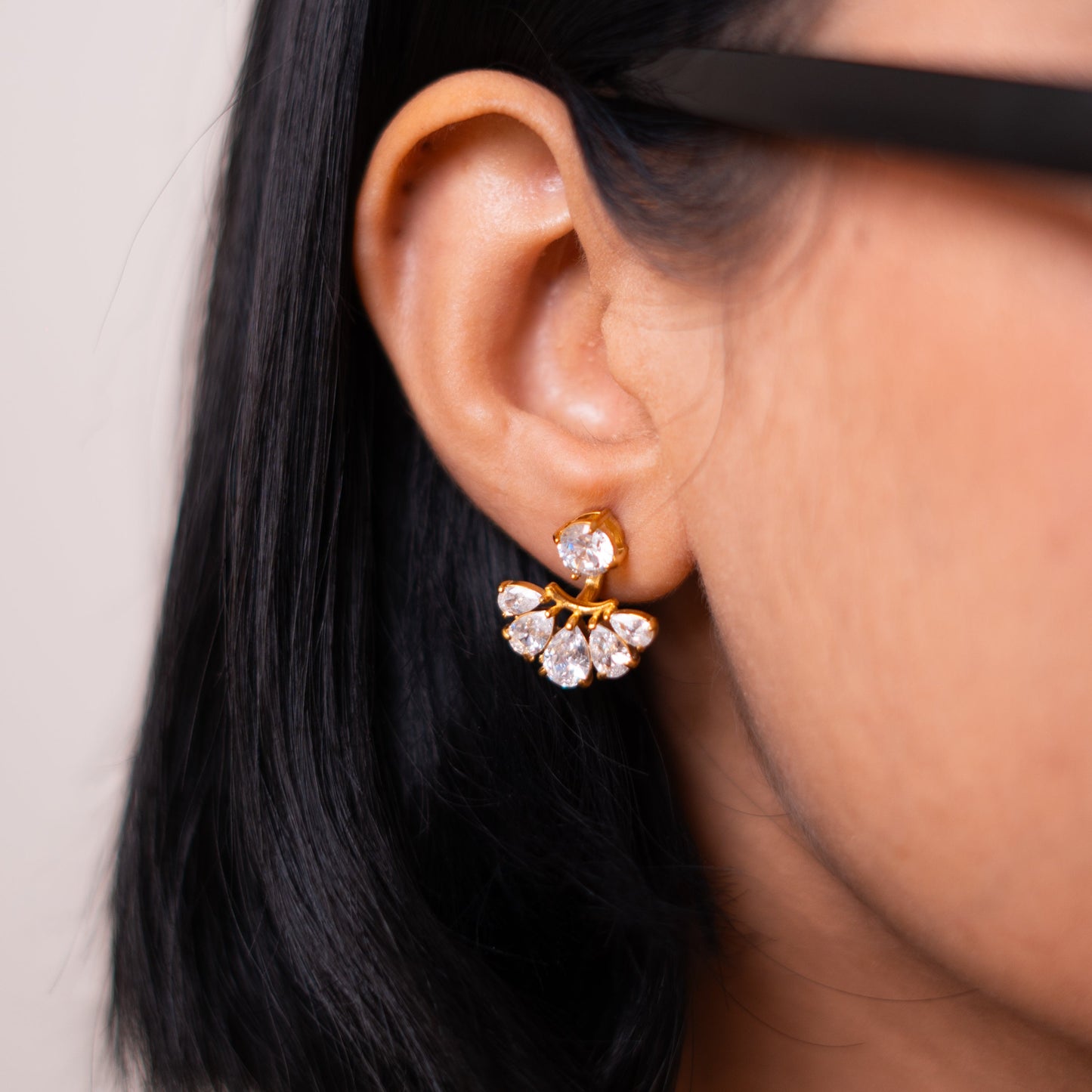 Sham'a ear jacket worn in profile, a round stud above a fan of pear-cut stones under the lobe